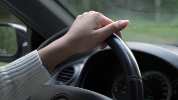 Señora cuidada en la mano de jersey blanco en el volante — Vídeo de stock