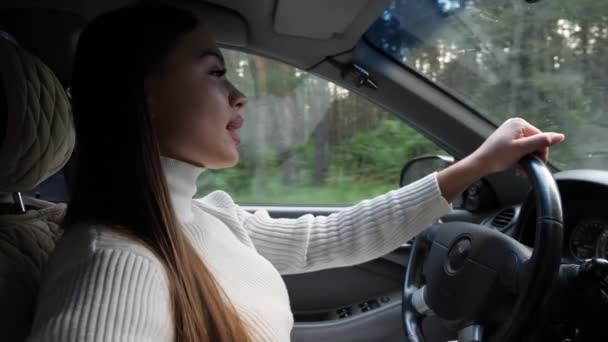 Красива молода жінка за кермом машини — стокове відео