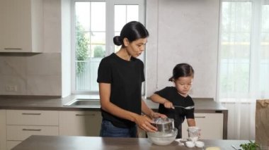 Anne ve kızı mutfaktaki bir klozete un atıyorlar. Küçük yardımcı