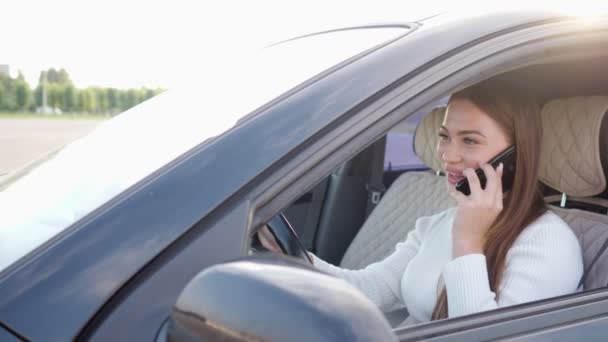 Güzel bir kadın araba kullanırken telefonda konuşuyor. — Stok video