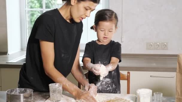 Mamma och dotter lagar något från degen i köket. — Stockvideo