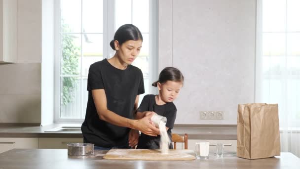 Mutter und kleine Tochter kochen in der Küche etwas aus Mehl — Stockvideo