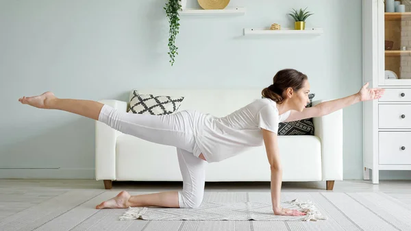 Pregnant woman does vyagrasana practicing yoga at home — Stock Photo, Image