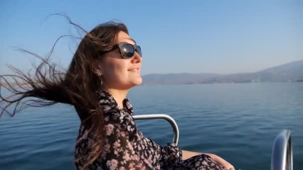 Jovem mulher fica no arco do barco navegando ao longo do lago azul calma — Vídeo de Stock