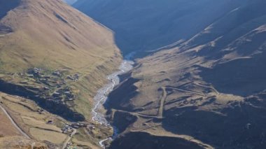 Dağların arasında kıvrılan uzun dar kanyon ve dere yatağı
