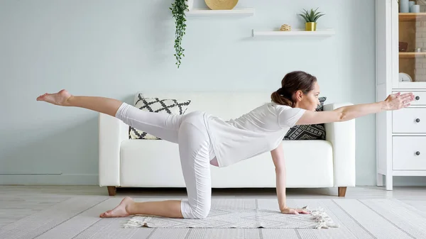 Pregnant woman does vyagrasana practicing yoga at home — Stock Photo, Image