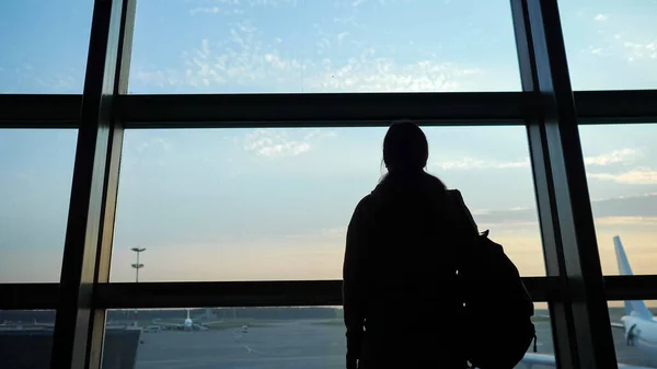 Силуэт человека, смотрящего в окно на самолеты — стоковое фото