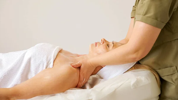 Cosmetologist experiente massagens jovem mulher ombros — Fotografia de Stock