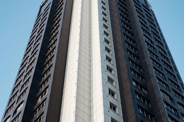Alto edificio in bianco e nero contro un cielo limpido, vista dal basso — Foto Stock
