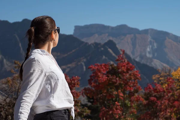 Mladá žena v černé sluneční brýle obdivuje velké skalnaté vrcholky — Stock fotografie