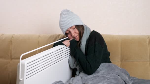 Jovem mulher abraços aquecedor sentado no sofá na sala de estar — Vídeo de Stock