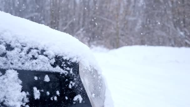 Primer plano de un faro de coche sobre un fondo de nieve que cae — Vídeos de Stock