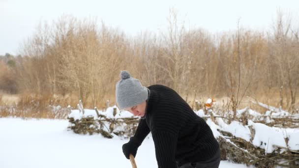 Joven lanzando nieve con pala de plástico amarillo — Vídeos de Stock