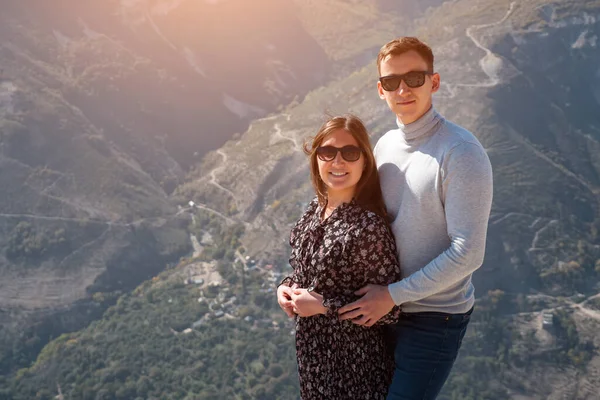 Ρομαντικό ζευγάρι με γυαλιά ηλίου ποζάρει στην κορυφή του λόφου πάνω από φαράγγι — Φωτογραφία Αρχείου
