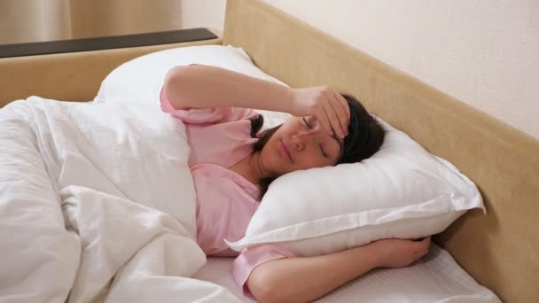 Lady removes sleeping mask stretches arms lying in bed — Stock Video