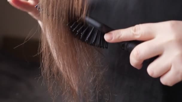 Mulher mãos pente dividido e sobresecado longo cabelo marrom termina — Vídeo de Stock