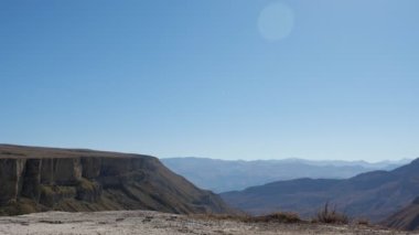 Çiftler dağlara karşı uçurumun kenarında el ele yürür.