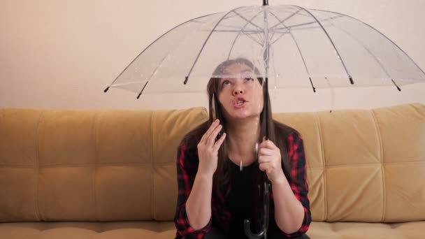 Mujer enojada llama fontanero escondido del agua bajo el paraguas — Vídeo de stock