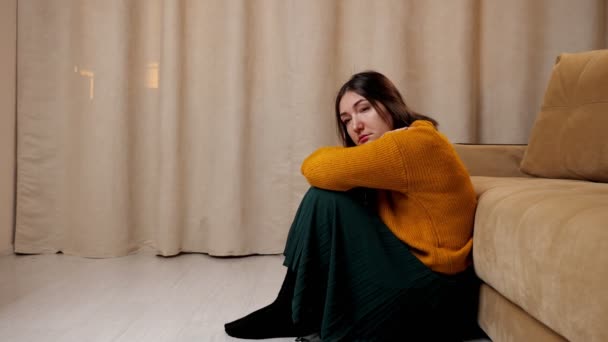 Hırkalı ve etekli depresif kadın tahta zeminde oturuyor. — Stok video
