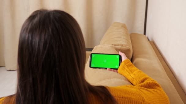 Mujer con el pelo largo suelto sostiene teléfono inteligente pantalla verde — Vídeos de Stock