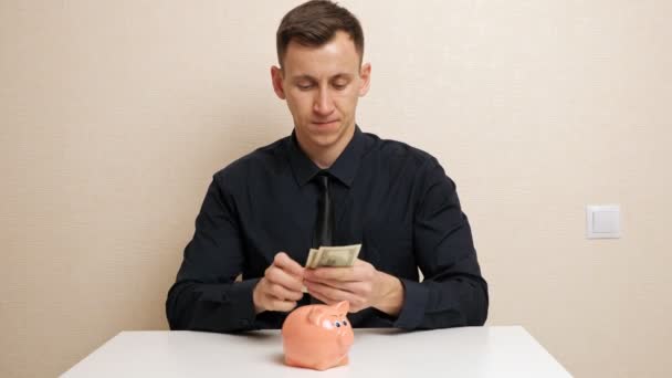 Чоловік рахує долари і ховає гроші в сорочці — стокове відео