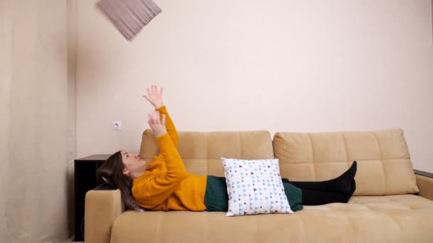 退屈若いです女性でセーターあります上のソファ投げ枕 — ストック動画