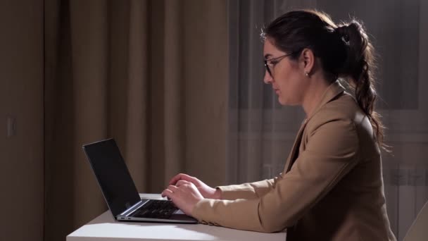Sleepy brunette types on laptop and takes off glasses — Stock Video