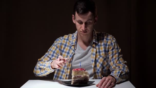 Triste cara na camisa quadriculada queima vela no bolo de aniversário — Vídeo de Stock