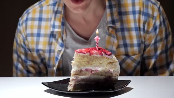 Хлопець у картатій сорочці вибухає рожева свічка для спалювання торта — стокове відео