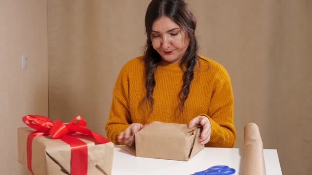 Sconvolta giovane donna che cerca di avvolgere un regalo in carta kraft la strappa nella rabbia — Video Stock