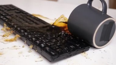 Bir fincan kahvenin yavaş çekimde klavyeye düşüşü.