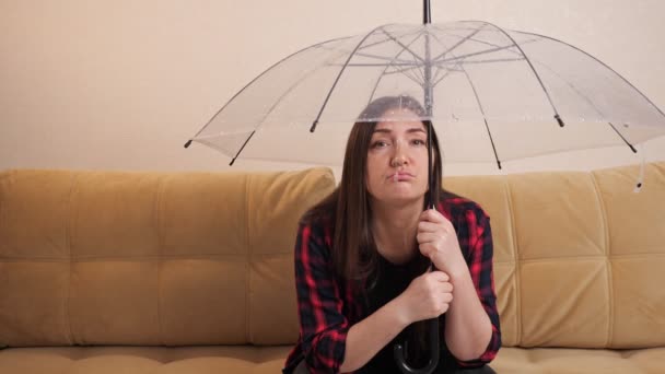 La donna pensierosa si nasconde dall'acqua che scorre sotto l'ombrello chiaro — Video Stock