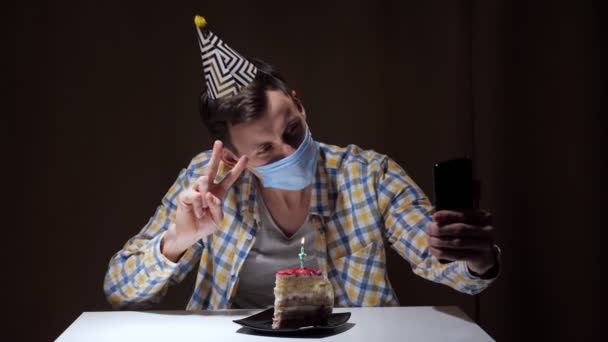 Guy en masque jetable parle avec des amis sur appel vidéo — Video