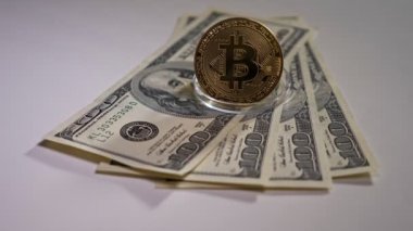 Bitcoin beyaz arka planda dolar banknotları üzerinde duruyor