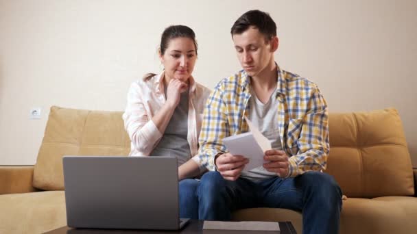 Zorgen familie opent envelop met goed nieuws in de woonkamer — Stockvideo