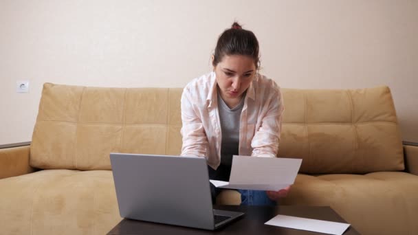La donna emotiva con conto calcola pagamenti su computer portatile — Video Stock