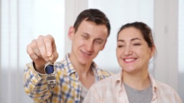 Aile, pencerenin yanındaki yeni dairenin anahtarlarına bakıyor.