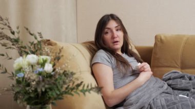 Alerjik kadın beyaz kağıt peçeteye hapşırır.
