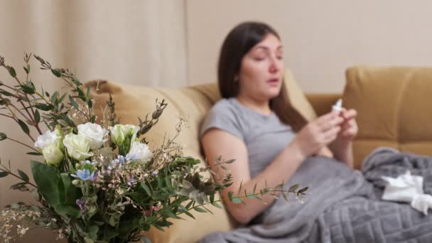 Signora offuscata con fiori allergia starnutisce in tovagliolo di carta — Video Stock