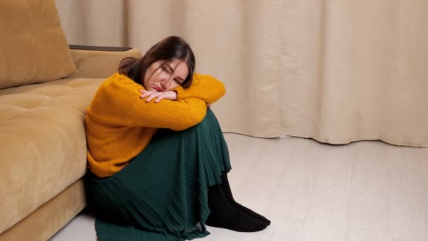 Deprimerad dam i tröja och kjol sitter på trägolv — Stockvideo