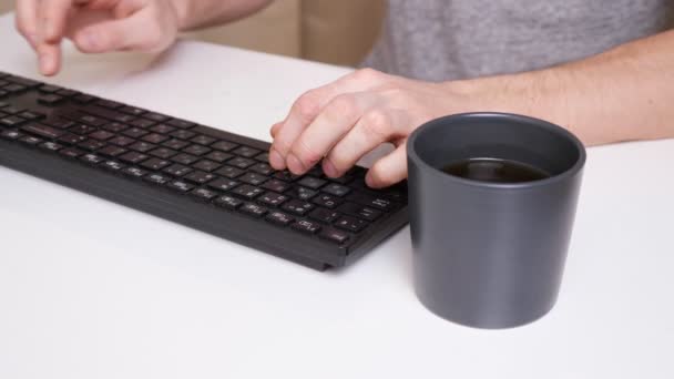 Nerozpoznatelný muž psaní na klávesnici počítače a házení kávy na něj — Stock video