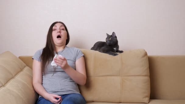 Junge Frau mit langen lockeren Haaren niest in kleine Serviette — Stockvideo