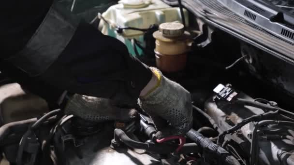 Механік в рукавичках розкручує деталь зламаного автомобіля — стокове відео