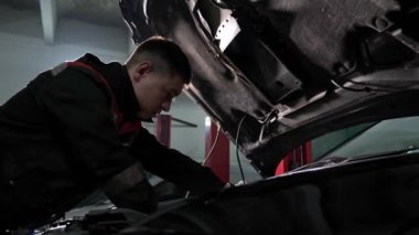 Araba tamirhanesinde yetenekli teknisyenler otomobil tamir eder.
