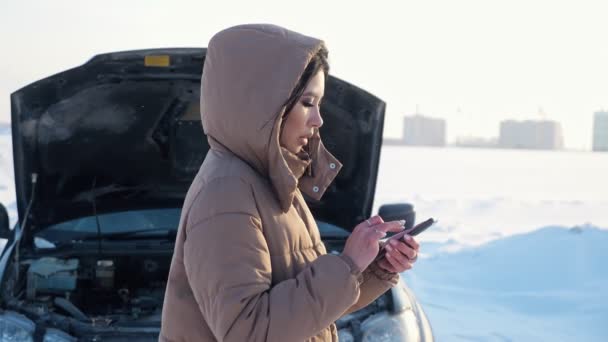 Žena s telefonem čeká na odtahovku poblíž rozbitého auta — Stock video