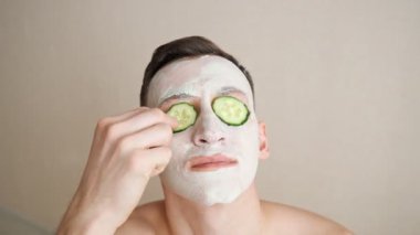 Yüzünde maske olan adam gözlerinden salatalık halkaları yiyor.