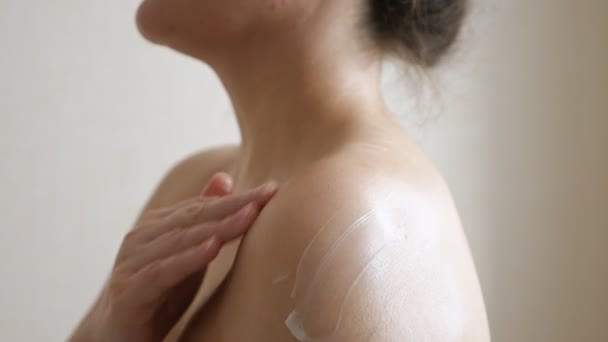 Mujer desnuda irreconocible unta hombro con crema — Vídeos de Stock