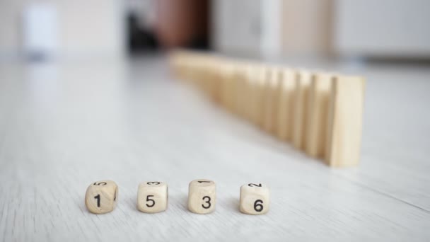 Chain reaction of wooden bricks and cubes with numbers on the floor slow motion — Stock Video