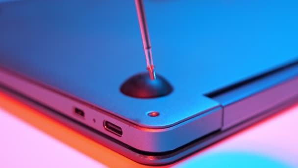 Nahaufnahme von Schraubbolzen in Laptop-Abdeckung in rotem Blaulicht — Stockvideo