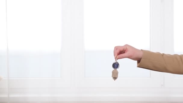 Hombre y mujer se dan la mano entregando las llaves del apartamento — Vídeos de Stock